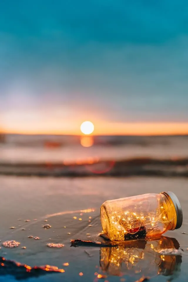 Glass mason jar on beach during sunset